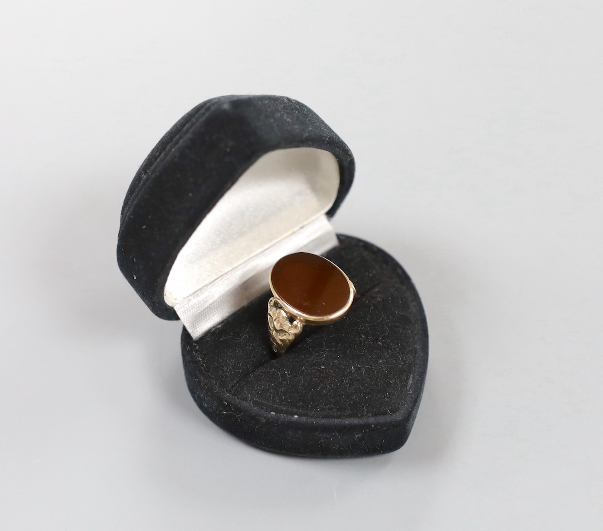 A 1970's Victorian style 9ct gold and carnelian set oval signet ring, with carved shoulders, size T, gross weight 6 grams.